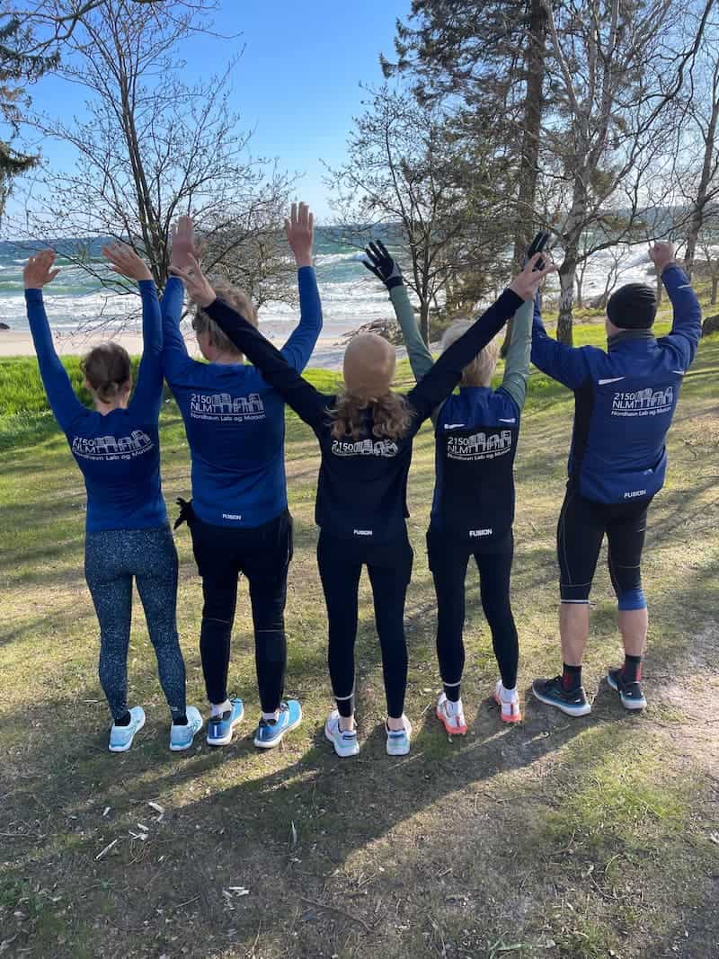 Group of friends cheering after their running trip on the beach