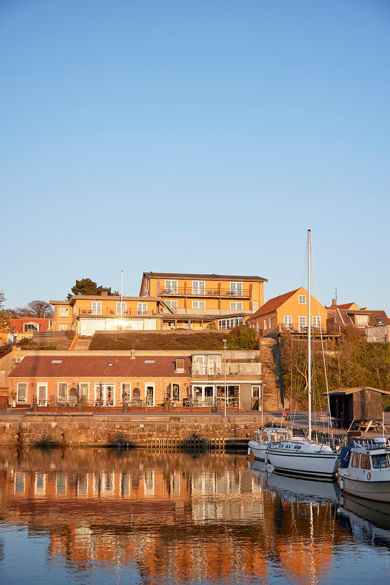 Bornholm accommodation at Hotel Kysten seen from the harbour with its picturesque boats